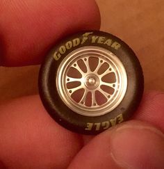 a person holding a small toy wheel in their hand with the words good year on it