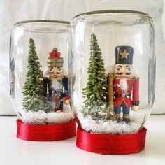 two snow globes with nutcracker and christmas tree inside