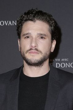 a man with black hair and beard wearing a suit