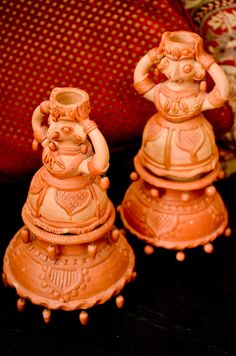 two clay figurines sitting next to each other on a table