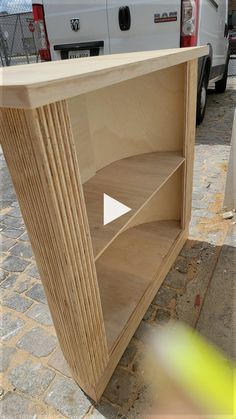 a white van parked next to a wooden shelf