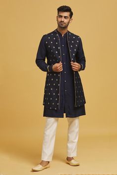 Navy blue silk nehru jacket with floral motifs applique embroidery. Comes with off-white cotton silk straight pant and a kurta.
Components: 3
Pattern: Applique embroidered
Type Of Work: Floral motifs
Neckline: Mandarin collar
Sleeve Type: Nehru Jacket: Sleeveless, Kurta: Full
Fabric: Silk, Pant: Cotton silk
Color: Blue
Other Details: 
Closure:
Kurta: Pearl buttons
Pant: Front fly and zip
Occasion: Sangeet - Aza Fashions Luxury Nehru Jacket With Zari Work For Transitional Season, Luxury Designer Silk Nehru Jacket, Luxury Nehru Jacket With Dabka Work For Winter, Luxury Nehru Jacket With Gold Embroidery For Formal Occasions, Luxury Fall Nehru Jacket For Semi-formal Occasions, Luxury Silk Nehru Jacket With Zari Work, Luxury Front Open Nehru Jacket For Eid, Luxury Silk Nehru Jacket For Men, Luxury Silk Nehru Jacket For Festivals