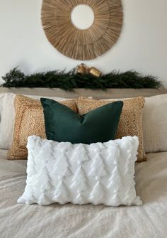 a bed with white and green pillows on top of it