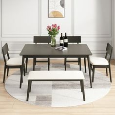 a dining room table with four chairs and a bench in front of it on top of a rug