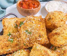 some fried food is on a plate with sauce and rice in the bowl next to it