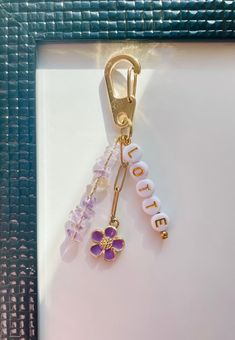 a keychain with two charms attached to it's side and the word doucet written in white letters