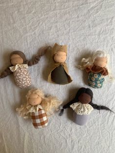 five dolls are laid out on a white sheet