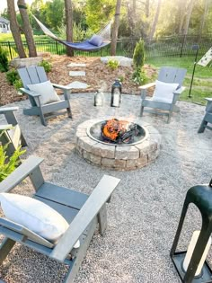 a fire pit surrounded by lawn chairs and hammocks