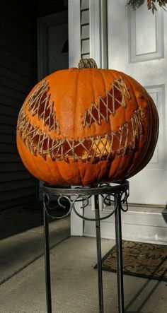 a large pumpkin sitting on top of a metal stand