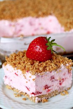 a piece of cake on a plate with a strawberry crumb topping next to it