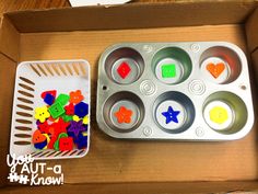 a box filled with cupcake tins next to a plastic container full of buttons