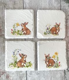 four coasters with rabbits and flowers painted on them