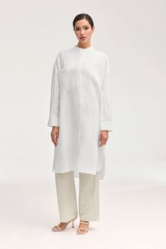 Elevate your summer wardrobe with our luxurious Linen Longline Button Down Top in White. Crafted from cool and breezy linen, this tunic-length cover up is perfect to wear as a standalone piece or a stylish layering option. Embrace effortless elegance in our white button down top. Model is 5'7" and is wearing size XS. White Cotton Summer Cover-up, Chic White Maxi Length Cover-up, White Cotton Poolside Cover-up, White Long Sleeve Relaxed Fit Cover-up, Dresses Flowy, Luxury White Maxi-length Kimono, White Dress Formal, Nikkah Dress, Dress Satin