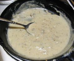 a pot filled with cream sitting on top of a stove next to a spatula