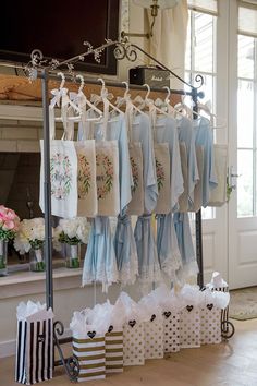 many bags are hanging on the clothes line in front of a store window with flowers