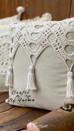 two white pillows with tassels on them