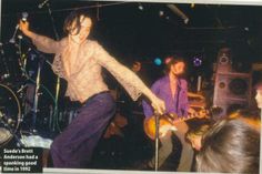 an old photo of a man on stage with his guitar