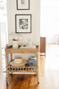 a shelf with hats, vases and pictures on it in a living room area