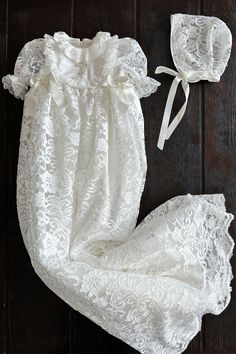 This beautiful white gown exudes elegance and tradition, making it a perfect choice for a girl's baptism ceremony. The garment is intricately crafted with delicate lace patterns, showcasing a meticulous attention to detail. The lacework, featuring floral motifs, adds a touch of vintage charm to the gown, reminiscent of timeless heirlooms passed down through generations.A standout feature is the embroidered cross on the chest, symbolizing the religious significance of the baptismal rite. The gown Silver Flower Girl Dress, Toddler Girl Christmas Dresses, Lace Baby Bonnet, Purple Flower Girl Dress, Flower Girl Dresses Blue, Toddler Christmas Dress, Lace Bonnet, Baby Party Dress, Pink Flower Girl Dresses