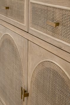 a wooden cabinet with rattan doors and handles