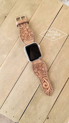 an apple watch band is sitting on top of a wooden table with the logo for leather co