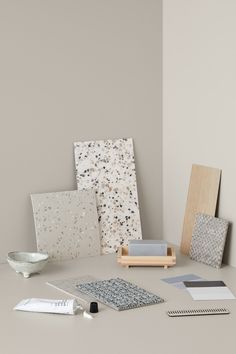 an assortment of art materials are displayed on a table with a bowl and other items