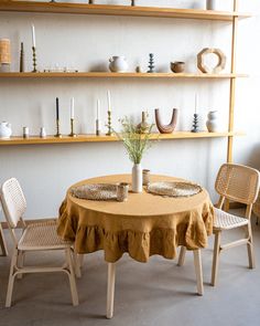 there is a table with two chairs and a vase on the table next to it