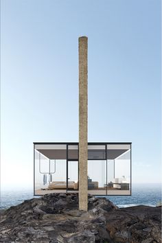 an unusual house on top of a rocky outcropping by the ocean with glass walls