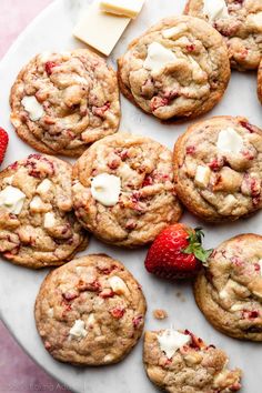 strawberry white chocolate chip cookies on a plate with butter and strawberries next to them