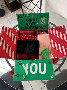 a christmas card box filled with lots of holiday cards and presents on top of a glass table