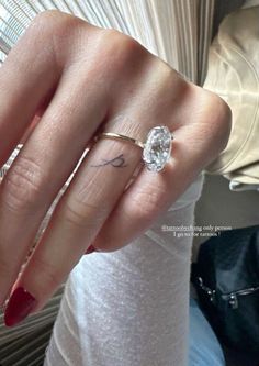 a woman's hand with a ring on it and a diamond in the middle