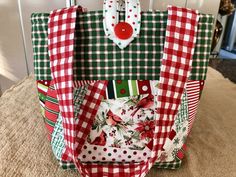 a red and green plaid bag sitting on top of a white tablecloth covered floor