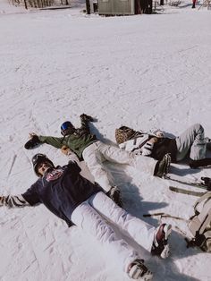 two people laying on the snow with skis