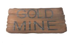 a wooden sign that says gold mine on it's side and the words are written in black ink