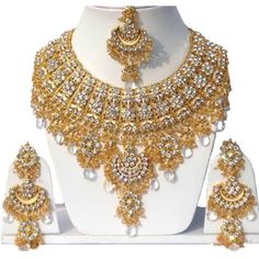 Product Description: * Gold Plated Jodha's Kundan Zerconic Bollywood Necklace Set Jewelry ES3 * The base metal color is Gold tone studded with kundan along with beads work on it. * This Jewelry set would add more charms to your beautiful jewelry collection and would surely bring lots of compliments . * Note:- This is an artificial Jewelry Set. * Care Instructions: Keep it dust-free & dirt free in a plastic pouch. Remember to apply your hairspray, perfume, and cosmetics before putting your je Golden Necklace Jewellery, Trendy Jewelry Earrings, Orang India, Tikka Jewelry, Wedding Designer, Golden Necklace, Bollywood Wedding, Gold Necklace Set, Jewelry Choker