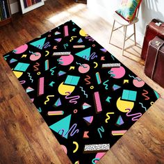 a black area rug with colorful shapes and numbers on the floor next to a chair