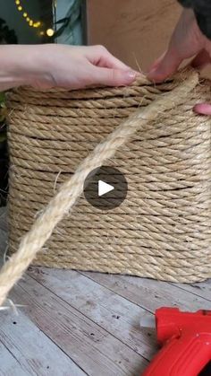 two hands are pulling rope from a basket