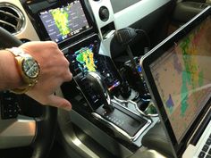 a man is using his laptop in the car while he sits at the steering wheel