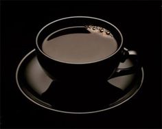 a cup of coffee on a saucer in the dark