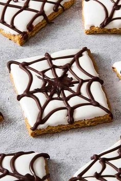 halloween treats with white frosting and chocolate spider webs on the top one is cut in half