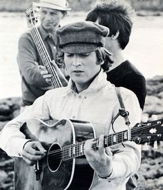 a man holding a guitar while standing next to other men