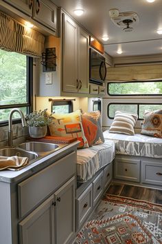 a kitchen area with sink, window and bed in the back side of an rv