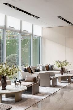 a living room filled with lots of furniture and large glass windows next to each other