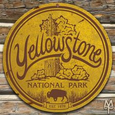 a yellow sign that says yellowstone national park on the side of a wooden fence with an image of a bison