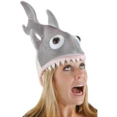 a woman wearing a shark hat with big eyes and teeth on it's head