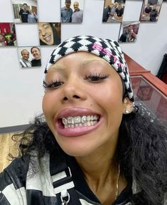 a woman with long black hair wearing a bandana smiles at the camera while sitting in an office