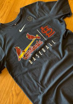 a t - shirt with the word cardinals baseball on it sitting on a wooden floor