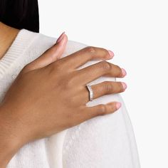 a woman's hand with a diamond ring on her left wrist, against a white background