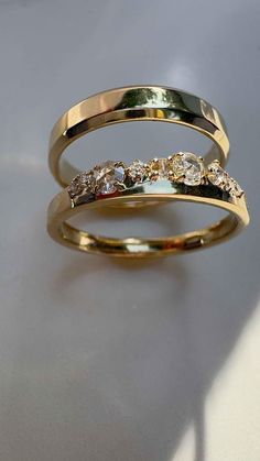 two gold rings with different colored stones on them