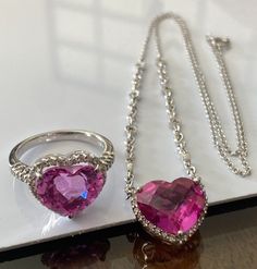 Estate 14k White Gold HALO Pink Sapphire Heart Diamond Ring Necklace Set Retail of over $5000 plus tax!! GORGEOUS NECKLACE and RING SET!!! Perfect for a gift! In Excellent Condition!! This gorgeous heart pendant necklace and ring set combines sparkle and impeccable taste! Necklace is intricately crafted in 14k white gold and the chain measures 17” long end to end. Chain has 4 small round diamonds on each side of attached heart pendant. The large faceted heart shaped pink stone measures approximately 10mm x 13mm and is surrounded by a halo of beautiful bright round cut diamonds! Thirty six (36) diamonds total on necklace! Large pink heart shaped stone on ring measures approximately 10mm x 13mm. Ring has thirty eight (38) round diamonds in halo and band. Size 7 Metal: 14K white gold Heart Sh Pink Sapphire Diamond Ring, Diamond Heart Ring, Gold Halo, Pink Stone, Sapphire Diamond, Heart Pendant Necklace, Diamond Heart, Gorgeous Necklaces, Round Cut Diamond